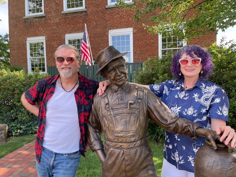 The duo standing either side of a bronze statue outside a brick courthouse